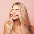 Blonde Frau mit langen, glaenzenden und voluminösen Haaren, laechelnd und zufrieden nach der Anwendung des Cocoair 2-in-1 Hairstylers, der föhnt und glättet gleichzeitig, für gesundes, geschmeidiges Haar ohne Hitzeschäden.
